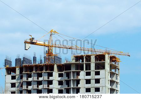 High crane on the construction of a multifamily urban residential building