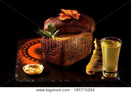 Cream soup with garlic inside the bread and traditional sauces with the glass of yellow horseradish vodka. Traditional cuisine.