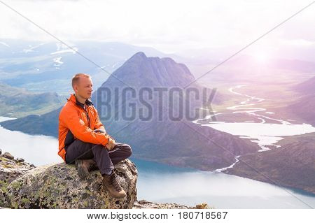 Young man hiking on Besseggen. Happy man enjoy lake and good weather in Norway
