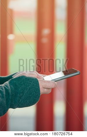 Close up of authentic female hands on the street using mobile phone to send text message