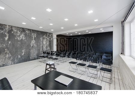 Modern university group study room with white desk and chairs.