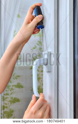 Close-up of the dismantling of an old window handle on a white pvc window.