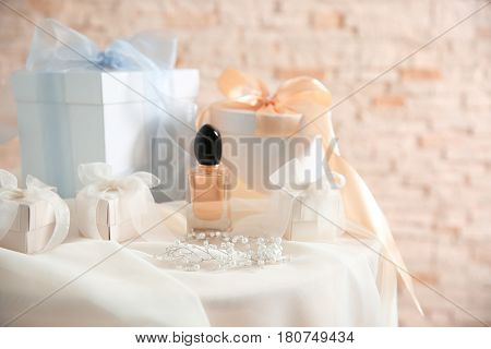 Table with gift boxes and perfume for wedding day