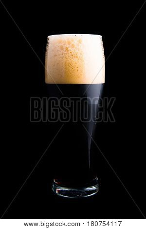 Dark beer in beer glass isolated on black background