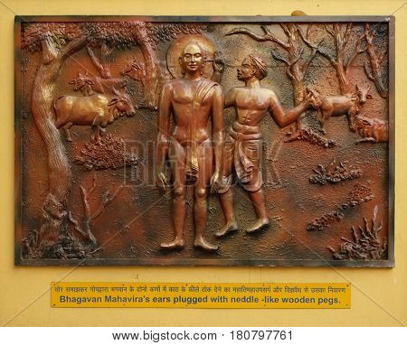 KOLKATA,INDIA - FEBRUARY 09, 2016: Bhagavan Mahaviras ears plugged with neddle - like wooden pegs, Street bass relief on the wall of Jain Temple (also called Parshwanath Temple) in Kolkata, India