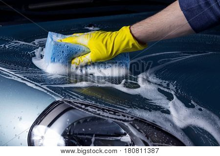 turquoise car is washing in soap suds