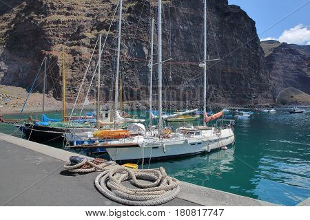 VALLE GRAN REY, LA GOMERA, SPAIN - MARCH 19, 2017: The village of Vueltas with sailing boats and cliffs in the background