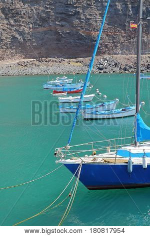 VALLE GRAN REY, LA GOMERA, SPAIN - MARCH 19, 2017: The village of Vueltas with sailing boats and cliffs in the background
