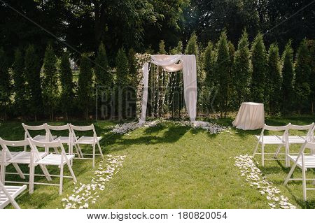 Beautiful wedding archway. Arch decorated with biege cloth and flowers, outdoor