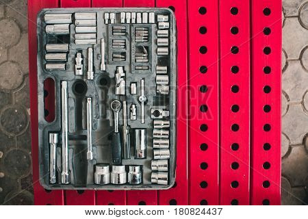A set of accessories for the tightening of bolts lying on the background of metal constructions of red color