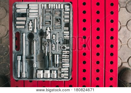 A set of accessories for the tightening of bolts lying on the background of metal constructions of red color