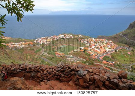 AGULO, LA GOMERA, SPAIN: General view of the village from a mountain trail with Teide volcano (Tenerife island) in the background