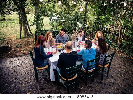 Group of friends at restaurant outdoors - People having dinner in a home garden