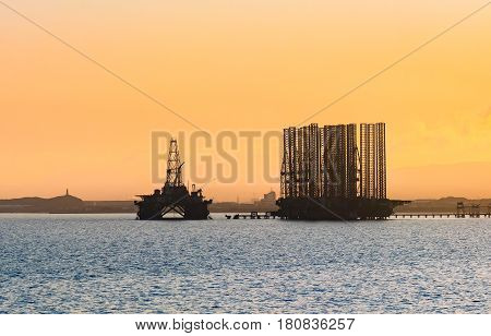 Oil platform in sea. Beautiful sunset calm sea