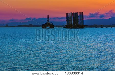 Oil platform in sea. Beautiful sunset calm sea