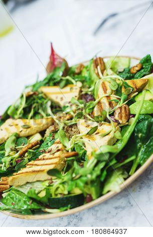Delicious vegetarian salad with tofu and vegetables. A plate of tasty and healthy food - vitamins and health. Soft focus.