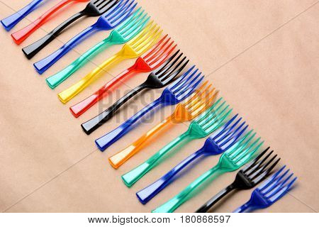 many color plastic forks on paper background