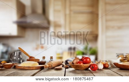 Baking ingredients placed on wooden table, ready for cooking pizza. Copyspace for text. Concept of food preparation, kitchen on background.
