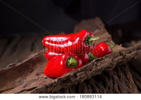 Red chilly pepper on wooden black background. Red hot chili peppers. Domestic cultivation extra hot chilli burn.