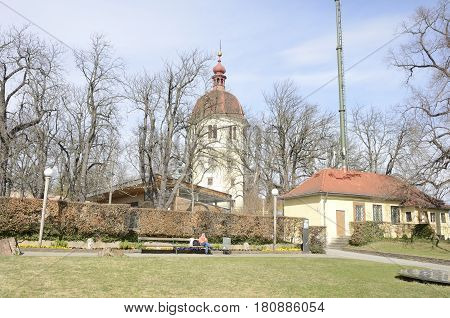 GRAZ, AUSTRIA - MARCH 20, 2017: Woman sitting on a bench at the hill Schlossberg with the background of the bell tower Glockenturm in Graz the capital of federal state of Styria Austria.