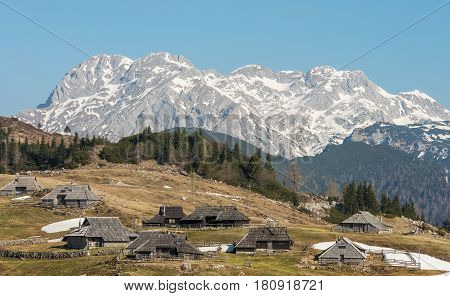 Scenic high alpine pasture Velika Planina and traditional old wooden shepherd cottages during spring time in Slovenia