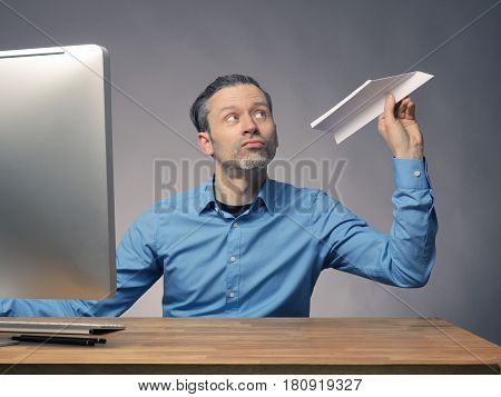Handsome businessman with a paper plane start up or upswing concept