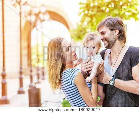 A young family couple with their cute little baby boy outdoors.