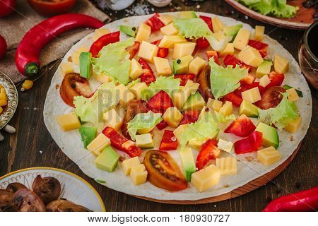 Tortilla With Salad Over It, Surrounded By Ingredients.