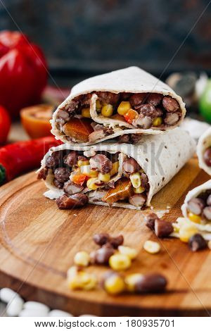 Nice Vegetarian Burrito Over Black Table On Wooden Board.