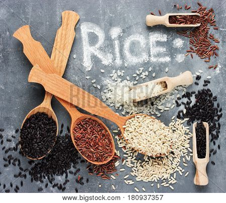 Black rice brown rice red rice in wooden spoons