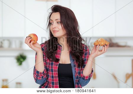 Diet. Dieting concept. Healthy Food. Beautiful Young Woman choosing between Fruits and Sweets. Weight Loss.