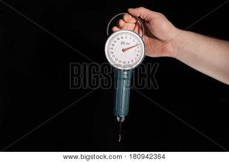 Man's hand holding the steelyard on black background