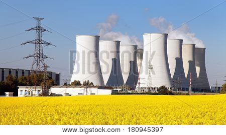 Panoramic view of Nuclear power plant Jaslovske cooling tower Bohunice with golden flowering field of rapeseed - Slovakia - two possibility for production of electric energy