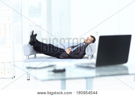 Satisfied businessman relaxing in his modern office