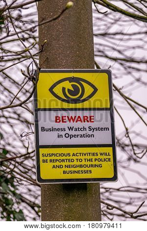Informative security warning sign on a wooden post
