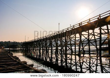 Saphan Mon (Mon Bridge) the large old wooden bridge across Song Karia river to the village reflecting with water located in Sangklaburi District Kanchanaburi Thailand