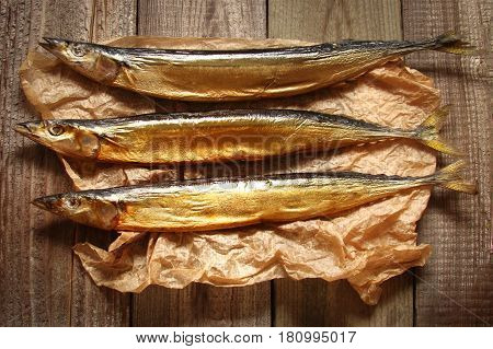 Fish saury smoked on paper and wooden boards