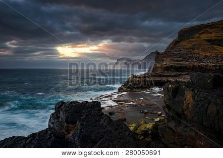 Bosdalafossur Waterfall On Vagar Island Coastline In Sunset, Faroe Islands