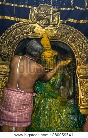 Belur, Karnataka, India - November 2, 2013: Chennakeshava Temple. Half Naked Priest Throws Turmeric 