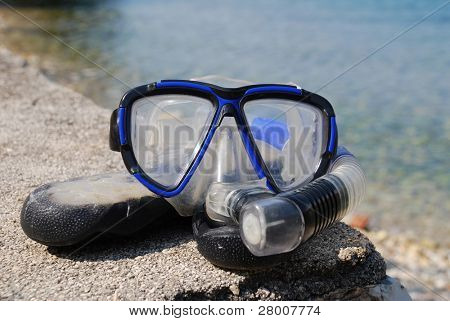 Un tuba et un masque sur le dessus une paire de chaussures de natation sur la plage de Spilia Bay sur l'île grecque