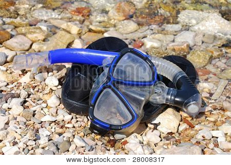 Un tuba et un masque portant sur le dessus de caoutchouc chaussures de nager sur la plage dans la baie de Spilia Meganissi Island