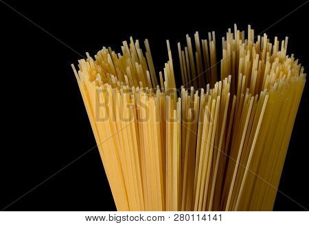 Yellow Long Spaghetti On Black Background. Yellow Italian Pasta. Long Spaghetti. Raw Spaghetti Bolog
