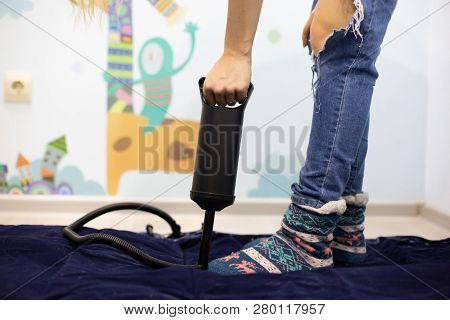 Woman With Hand Air Pump Inflatable Mattress Or Inflatable Bed At Home. Body Part, Selective Focus