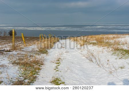 Winter Landscape With Earth Road Leading Down To Kakhovka Reservoir Located On The Dnipro River Near