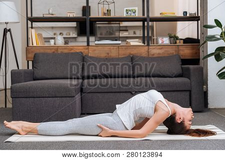 Woman Practicing Fish Pose At Home In Living Room