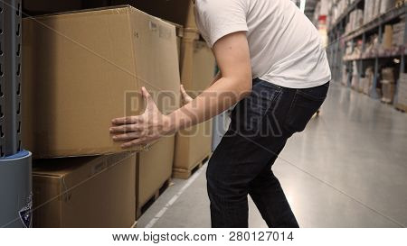 Warehouse Large Storage Or Logistic Or Cargo For Distribution. And Man's Hand Is Picking Up A Box.