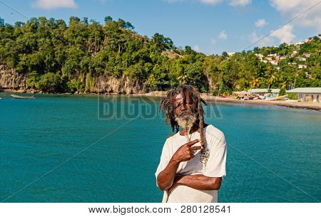 Castries, St.lucia - November 26, 2015: African Man Show Victory Or Peace Gesture On Blue Sea. Old H