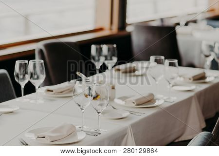 Catering And Celebration Concept. Festive Served Dinner Table With Glasses And Cutlery On White Tabl