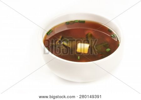 A Photo Of A Bowl Of Miso Soup With Tofu, Scallions, And Wakame Algae, On A White Background With Co