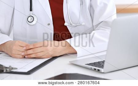 Close-up Of A Unknown Female Doctors Hands. Physician At Working Place Ready To Consult And Halp Pat
